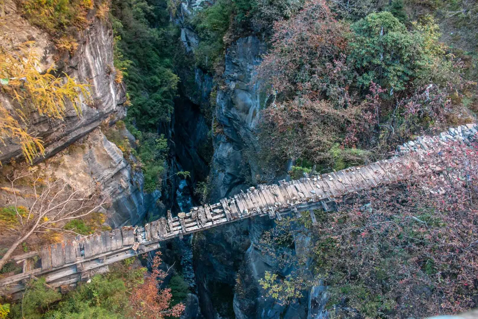 Old wooden bridge spanning a narrow rocky gorge