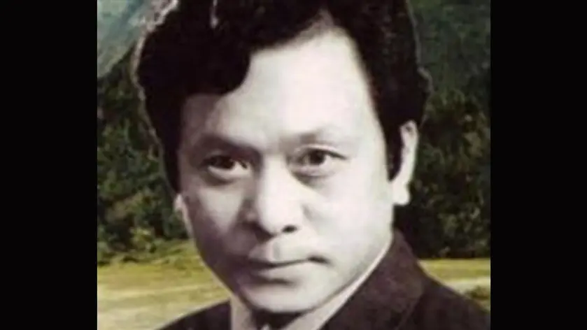 Black-and-white portrait of a man with thick dark hair