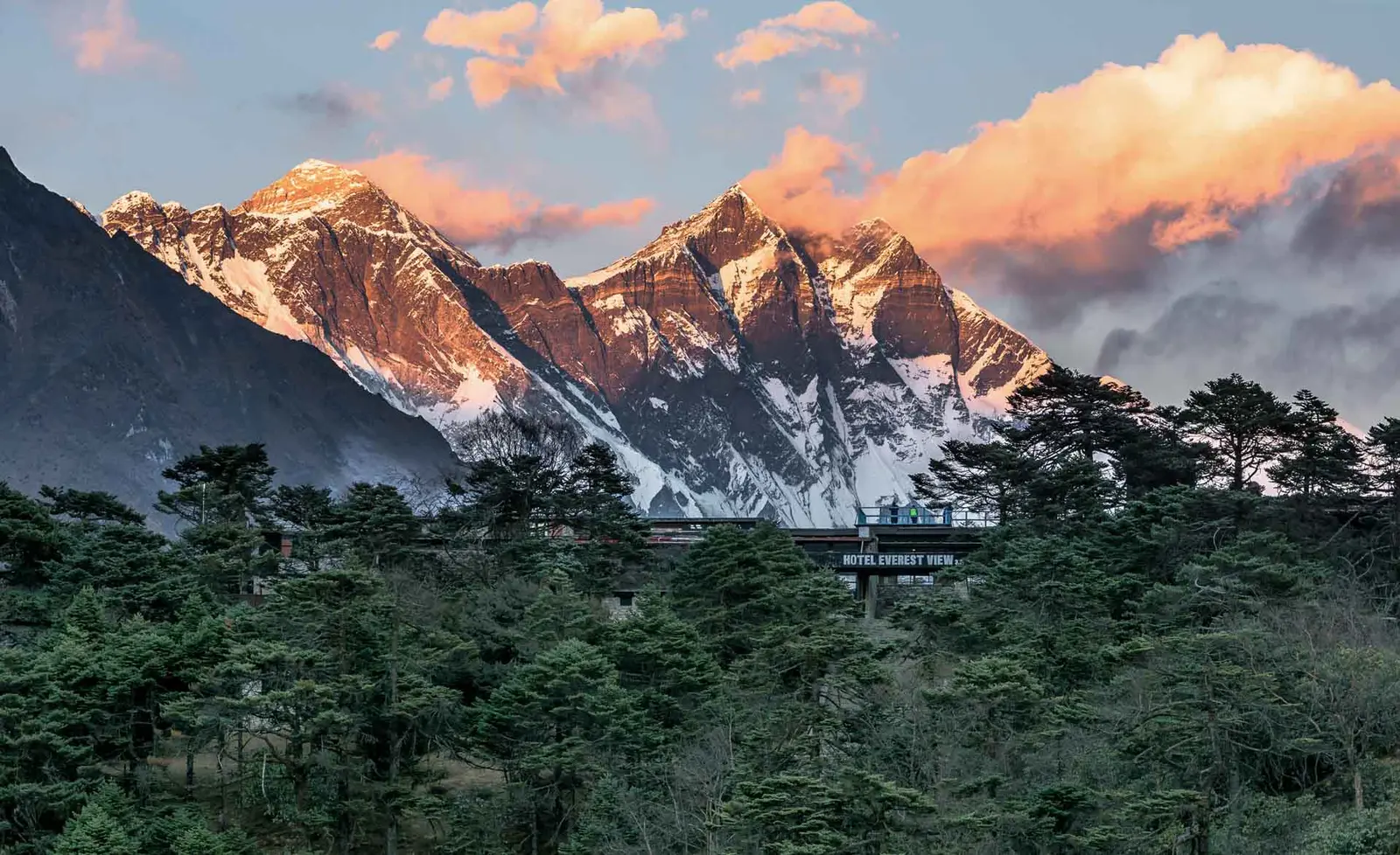Everest and Lhotse mountains glowing at sunset above Hotel Everest View in the forest